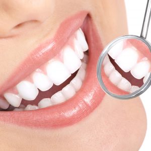 Healthy woman teeth and a dentist mouth mirror